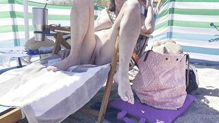 Wife chilling out at the naked beach speads her legs.