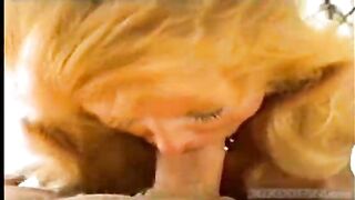 Aged golden-haired woman is sucking her lover's penis in a POV style, during the day