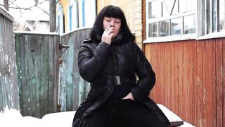 Smokin' outdoors underneath Christmas snow. Brunette Hair in a coat on a undressed body and with a cigarette in red lips. Amateur fetish in a public place. Fingering beneath warm tights. ASMR.
