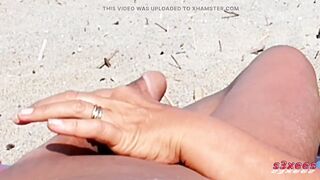 That babe shows her butt on the beach of Cap d'Agde and jerks off her snatch and then her boyfriend's penis with voyeurs