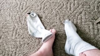 Takes perspired, ribald work socks off and shows feet!